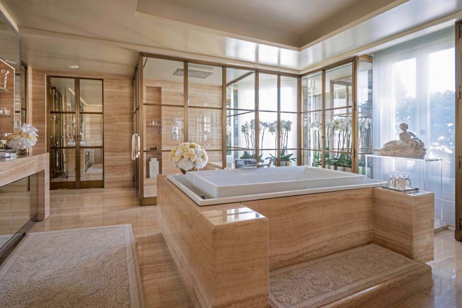 Conçue par Pierre Yves-Rochon, la salle de bain se concentre sur une baignoire à débordement avec des systèmes d'hydromassage et de chromothérapie. Le plan de toilette est éclairé par des luminaires Baccarat et le revêtement en marbre ajoute une touche élégante.