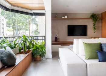 Banco faz as vezes de baú e de jardineira em apartamento de 140 m²