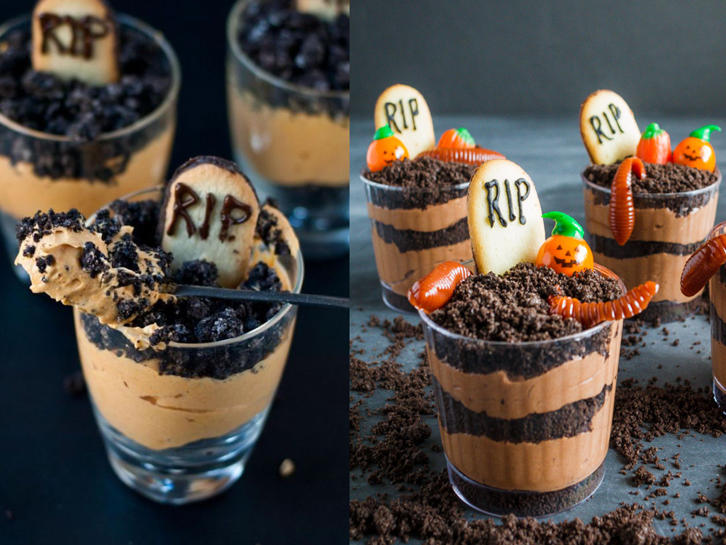 Tasses en verre remplies de gâteau à la crème et au chocolat et décorées sur le thème d'Halloween, comme des bonbons à la gelée de vers et des biscuits en forme de tombe
