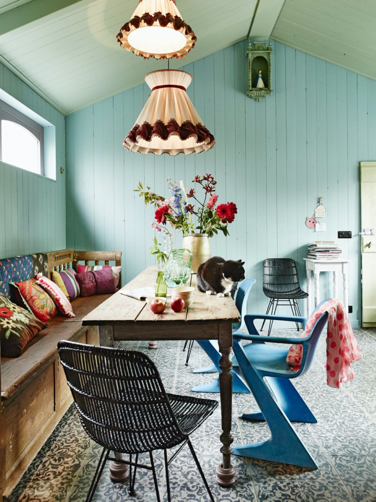 Salle à manger avec mur végétal et chaises colorées