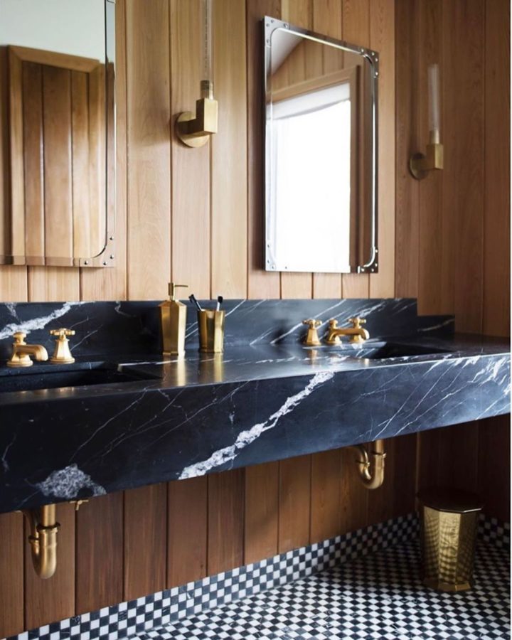 salle de bain avec meuble-lavabo en marbre de luxe et boiseries dorées et parquet noir et blanc