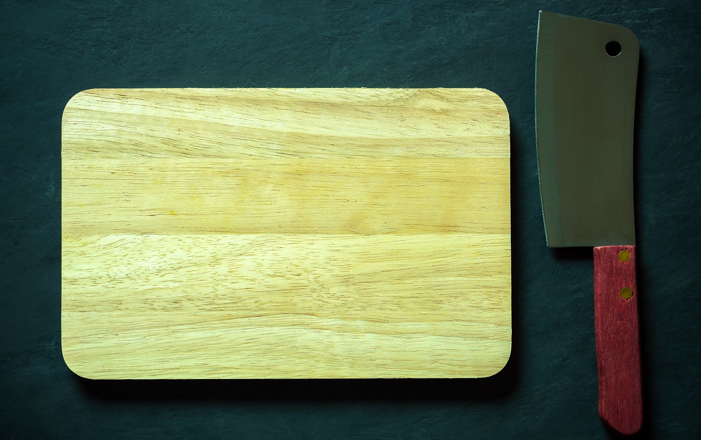 Planche à découper en bois et couteau de chef chinois sur un sol en ciment noir.  Vue de dessus et espace de copie pour le texte.  Concept d'ustensiles de cuisine et de cuisine.