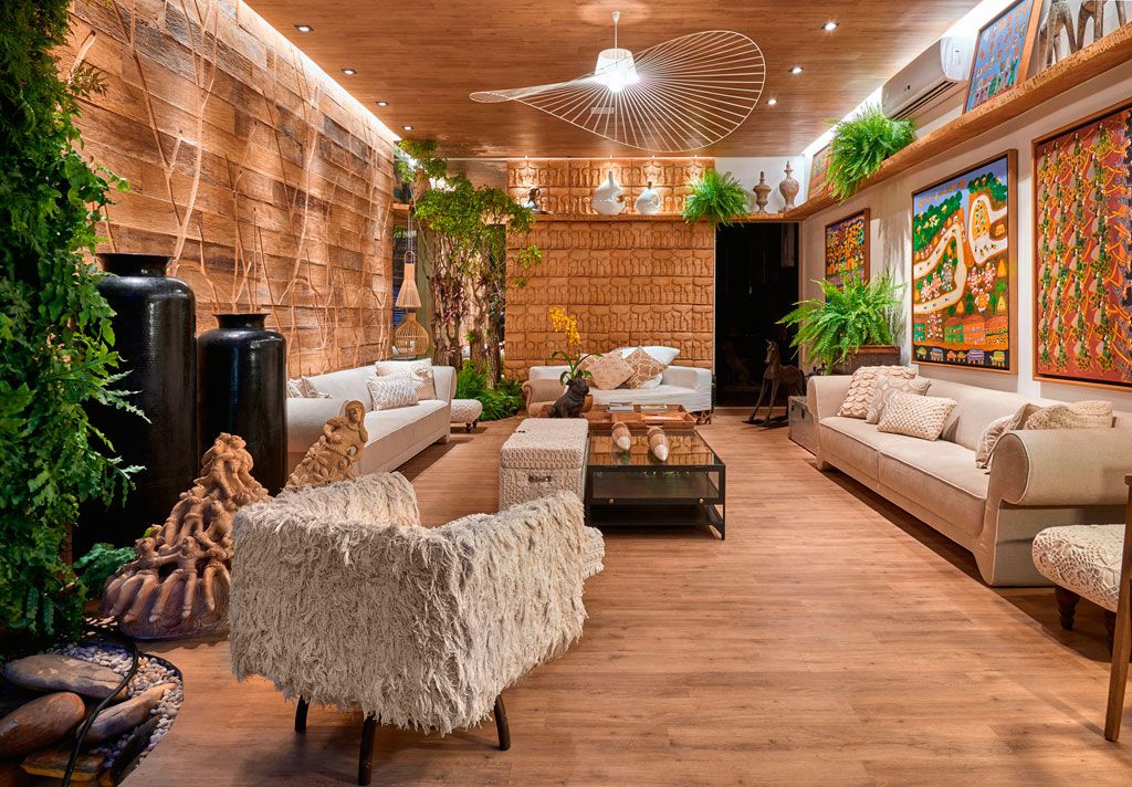 Salon en bois avec murs en briques et parquet.  Canapés et fauteuils blancs.  Photos sur les murs 