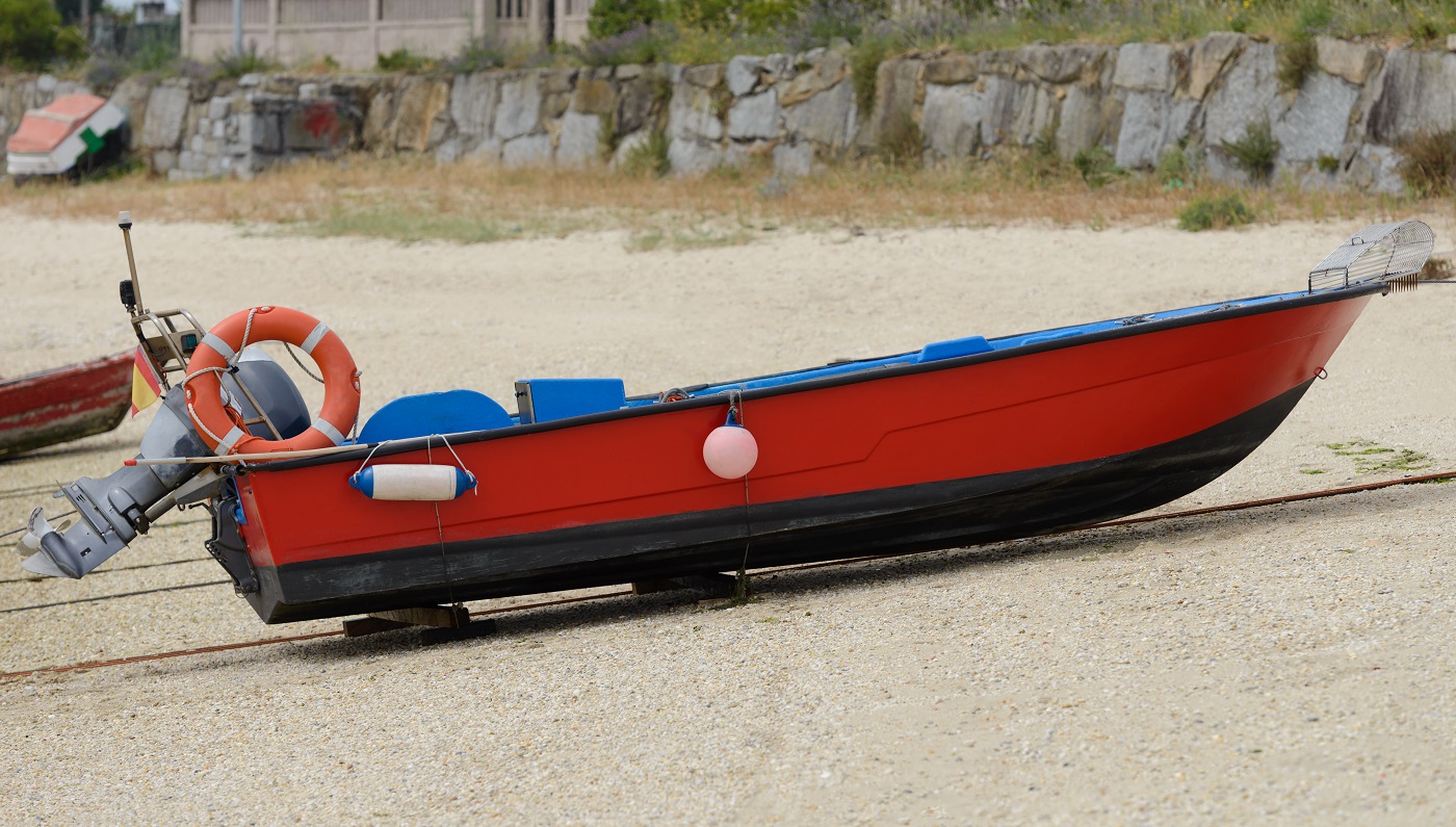 image de bateau à moteur de pêche en bois rouge sèche à terre