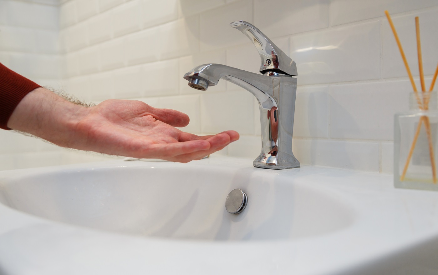 Homme tenant sa main sous le robinet ouvert sans eau.  Coupure de l'alimentation en eau pour non-paiement ou lors de travaux de réparation du système central