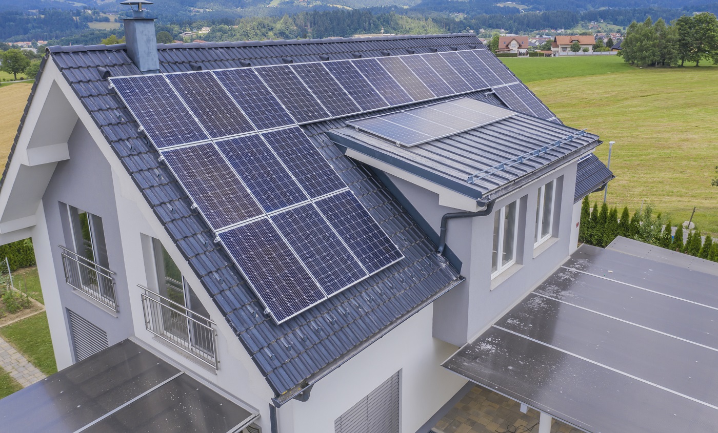 Capture en grand angle d'une maison privée située dans une vallée avec des panneaux solaires sur le toit
