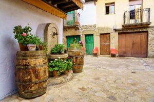 Vieux village avec des tonneaux avec des plantes et des fleurs dans la rue, Sequeros, Salamanca.  Pierre et brique