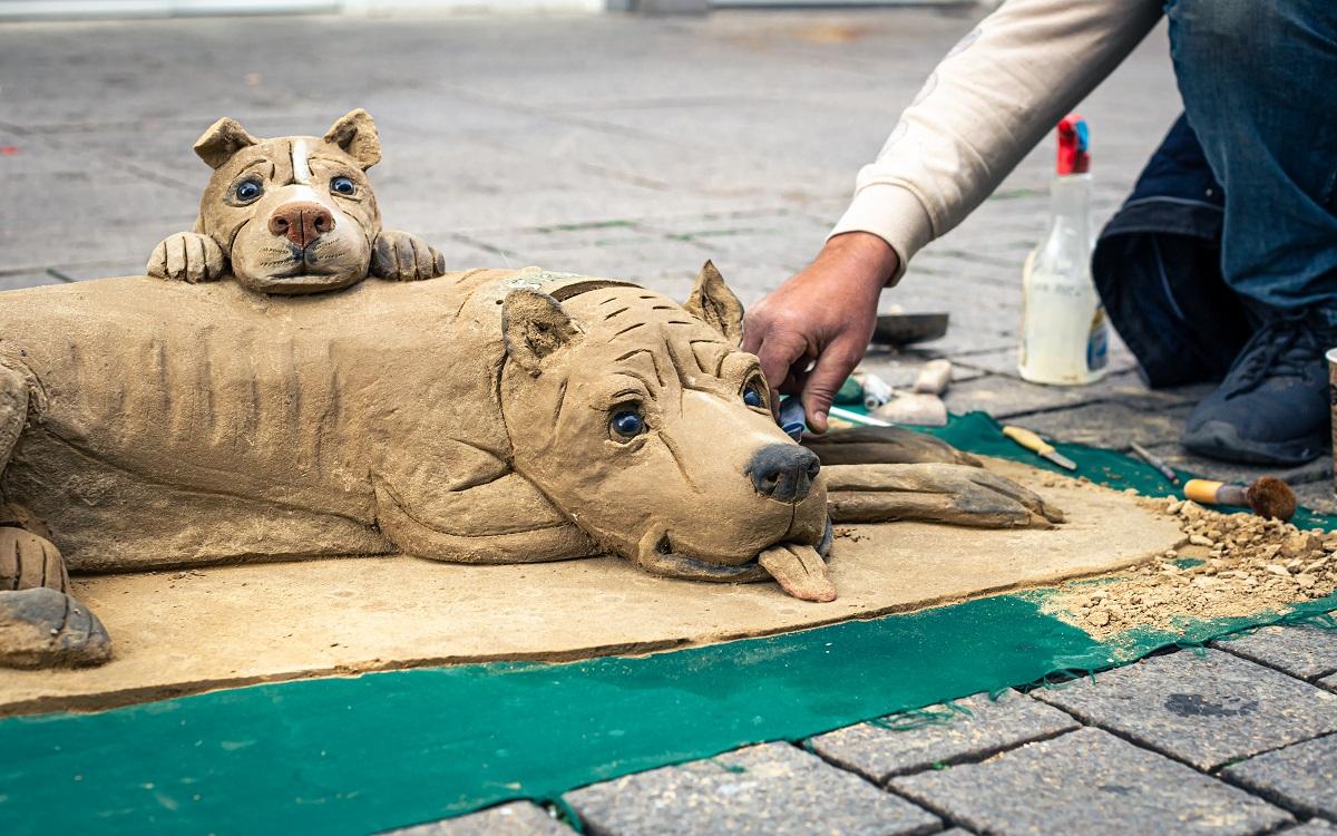 Sculpture d'un chien en argile, modelage en argile dans la rue, un homme sculpte en argile.  Meilleures idées de modelage d'argile.