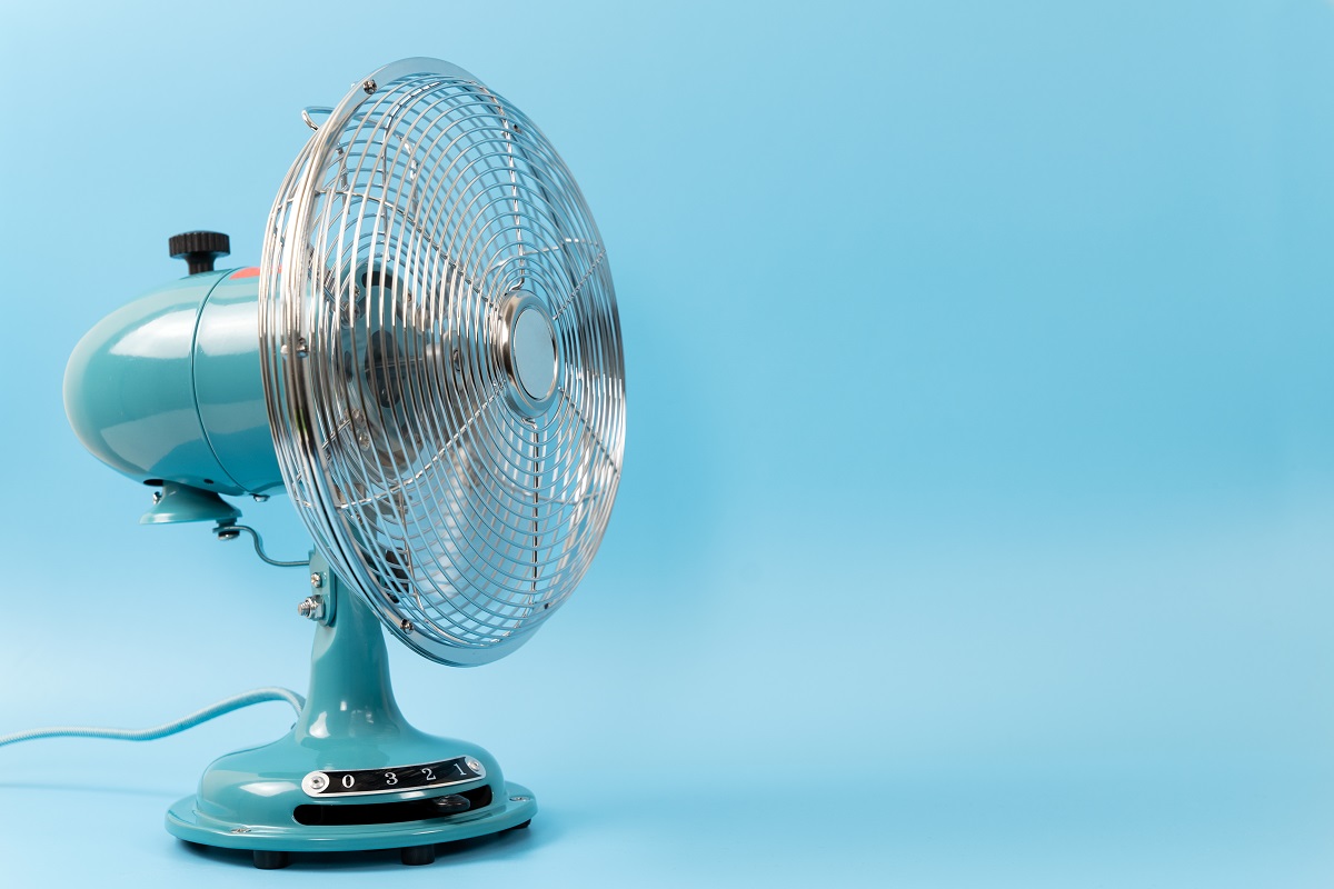 Ventilateur de table rétro vintage isolé sur fond bleu.  Quel ventilateur souffle l'air le plus froid.